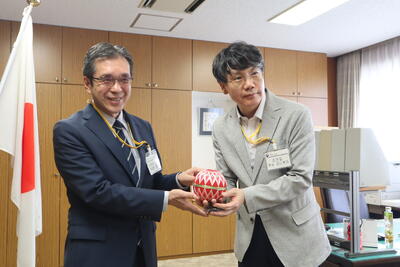 記念品の加賀手毬を贈呈する様子の写真