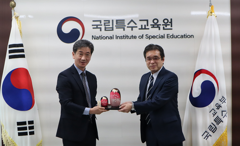 記念品のこけしを贈呈する様子の写真